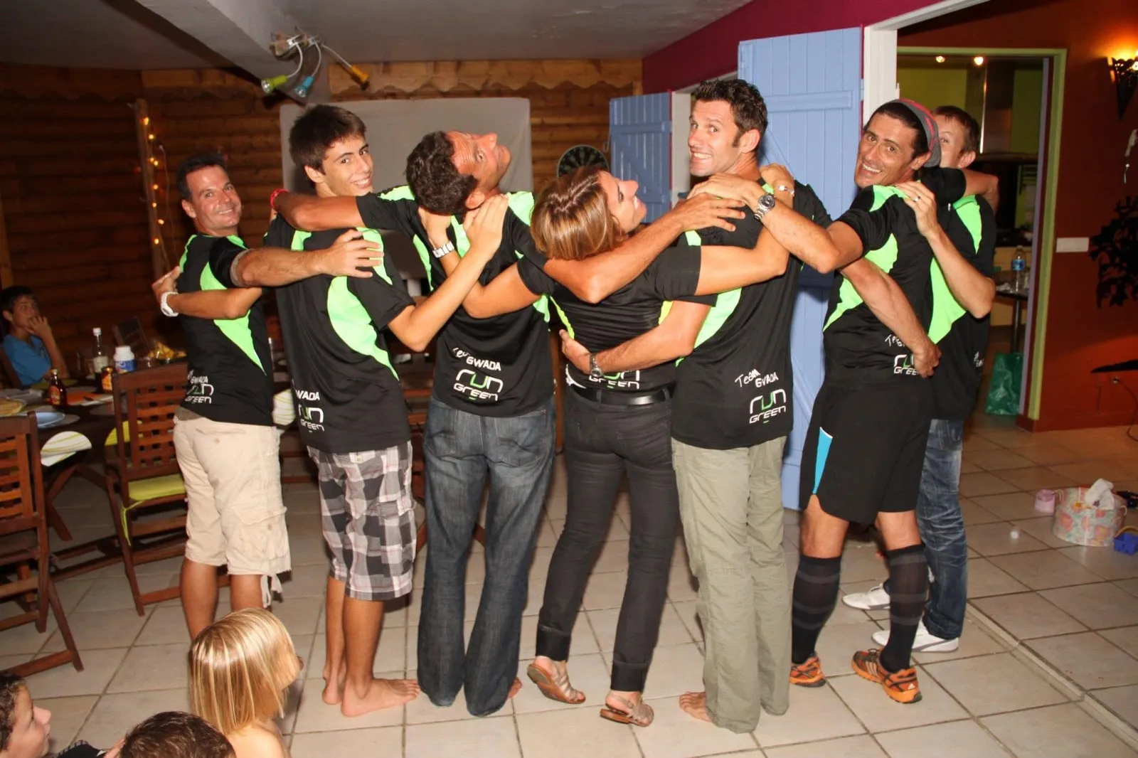 Les membres de la Team Gwada Run Green, bras dessus bras dessous, de dos avec leurs maillots noir et vert de l'association